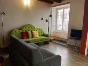 sala de estar con sofá verde y TV en Residenza Montecchi, en Verona