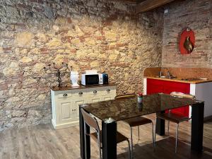 a kitchen with a table and a stone wall at Residenza Montecchi in Verona