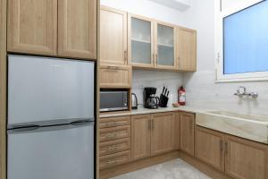 kuchnia z drewnianymi szafkami i lodówką w obiekcie Presidential Apartment by Athens Stay w Atenach
