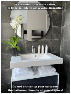 lavabo blanco en el baño con espejo en Maison Hyper Centre d’Arras, en Arras