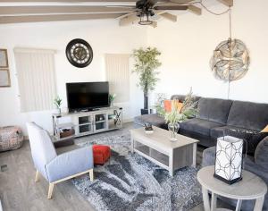 sala de estar con sofá y TV en Joshua Tree National Park - Cozy Palms Getaway, en Twentynine Palms