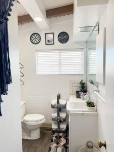 een witte badkamer met een toilet en een wastafel bij Joshua Tree National Park - Cozy Palms Getaway in Twentynine Palms