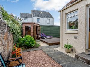 a patio with purple chairs and a house at Chilmello Cottage in Pittenweem