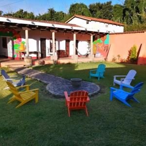 un grupo de sillas sentadas en el césped frente a una casa en Hostel Hopa Antigua, en Antigua Guatemala