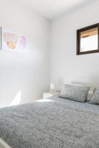 - une chambre blanche avec un lit et une fenêtre dans l'établissement Home2Book Lovely Beachfront Apt Arinaga Green, à Arinaga