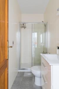 La salle de bains est pourvue de toilettes et d'une douche en verre. dans l'établissement Home2Book Lovely Beachfront Apt Arinaga Green, à Arinaga