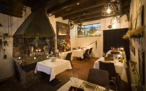 a restaurant with tables and chairs and a fireplace at Stadslogement De Oude Smidse Steenwijk in Steenwijk