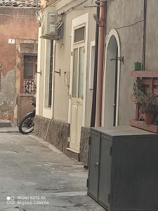 カターニアにあるCutelli Appartamentの建物と路上に駐車されたバイクのある路地 +4枚の写真