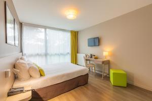una camera d'albergo con letto, scrivania e finestra di Appart’City Confort Rennes – Cesson Sévigné a Cesson-Sévigné