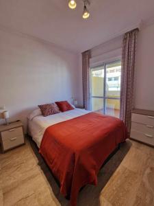 a bedroom with a large bed and a window at 2 rooms con piscina litoral in Málaga