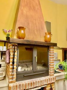 Bedmar的住宿－Vivienda Rincon de Mágina，砖砌壁炉,上面有两瓶花