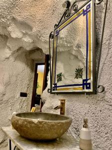 a bathroom with a stone sink and a mirror at Vivienda Rincon de Mágina in Bedmar