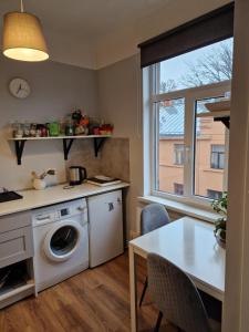 een keuken met een wasmachine en een tafel bij Artilerija's apartment in Rīga