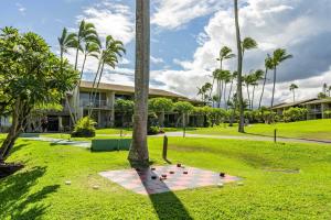 a group of birds sitting on the grass in front of a building at Napili Shores A203 OF Studio condo in Kahana