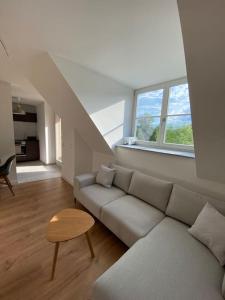 a white living room with a couch and a table at Modernes Apartment in zentraler Lage in Chemnitz
