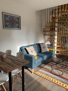 a living room with a blue couch and a table at Adorable Guest House « bienvenue chez vous ! » in Bordères-sur-lʼÉchez