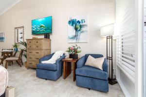 a living room with two chairs and a tv at Napili Shores A203 OF Studio condo in Kahana