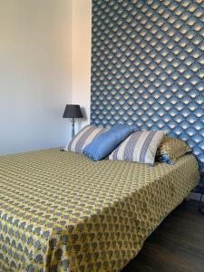 Adorable Guest House « bienvenue chez vous ! » في Bordères-sur-lʼÉchez: سرير في غرفة نوم مع اللوح الأمامي كبير