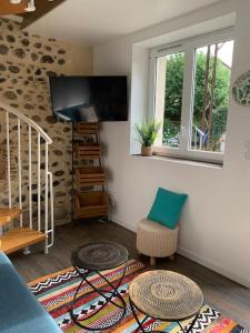 a living room with two tables and a tv at Adorable Guest House « bienvenue chez vous ! » in Bordères-sur-lʼÉchez