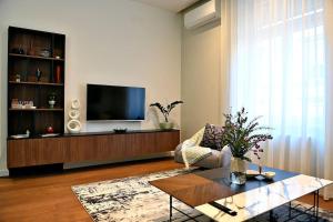 ein Wohnzimmer mit einem TV, einem Sofa und einem Tisch in der Unterkunft Nino Luxury Apartment in Zagreb