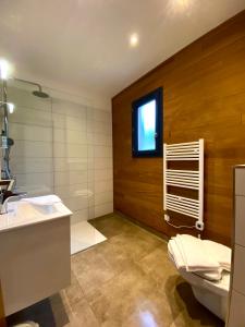 ein Bad mit einem Waschbecken, einem WC und einem Fenster in der Unterkunft Résidence Les Pavillons du Golfe in Favone