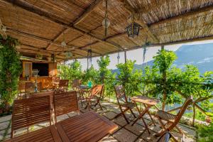 a patio with chairs and tables and a view of the mountains at Poggio Angelarosa: Lemon Garden Stay&Relax in Scala