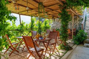 un patio con mesa y sillas bajo un techo en Poggio Angelarosa: Lemon Garden Stay&Relax en Scala