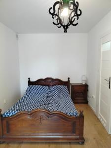Ce lit se trouve dans un dortoir doté d'un lustre. dans l'établissement Apartament Oliwia, à Grywałd