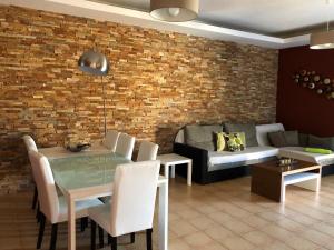 a dining room with a table and a brick wall at Casa Acebuche in La Oliva