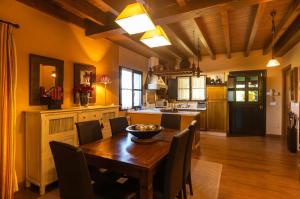 cocina grande con mesa de madera y sillas en Villa vacacional el Castañin, en Pancar