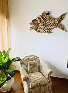 una sala de estar con una silla y un pez en la pared en Casa Posillipo NA en Nápoles
