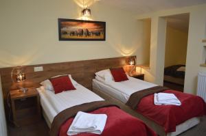 a hotel room with two beds with red and white towels at Hotel Ajax in Janki
