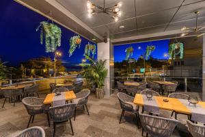 a restaurant with tables and chairs and a large window at Vega Hotel in Galaţi