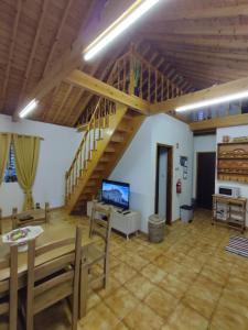 a large living room with a staircase and a television at Casa Caminho da Barca in Madalena