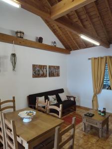 a living room with a table and a couch at Casa Caminho da Barca in Madalena