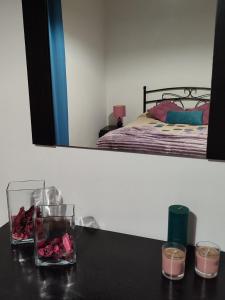 - une table avec deux bougies et des fleurs dans la chambre dans l'établissement Casa Caminho da Barca, à Madalena