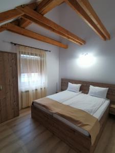 a bedroom with a large bed in a room with wooden floors at Hanul Greweln in Mediaş