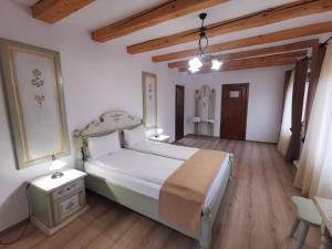 ein Schlafzimmer mit einem großen Bett und Holzböden in der Unterkunft Hanul Greweln in Mediaş