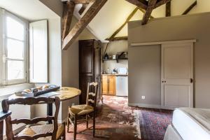 uma cozinha com mesa e cadeiras num quarto em L'hôtel de Panette, chambres indépendantes, charpente historique em Bourges