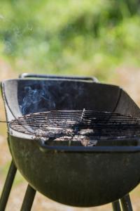 a charcoal grill with smoke coming out of it at Kauksi Campsite in Kauksi