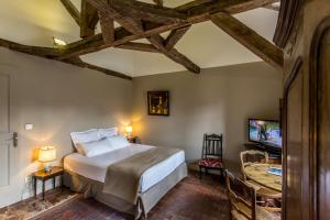 um quarto com uma cama grande e uma televisão em L'hôtel de Panette, chambres indépendantes, charpente historique em Bourges