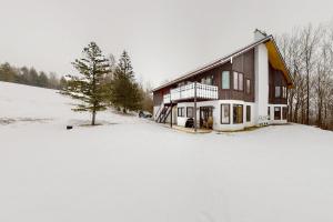 a house in the snow with a snow covered yard at Best Views of Mt Washington in Bartlett