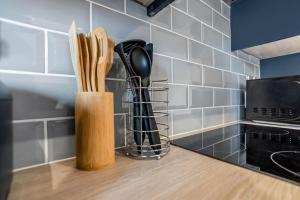 un bancone della cucina con utensili in legno in un blocco di coltelli di 8 Beds Denmark House a Norwich