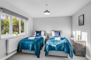 8 Beds Denmark House في نورويتش: غرفة نوم بسريرين ونوافذ