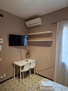 a room with a table and a tv on the wall at San Pietro Apartment in Padova