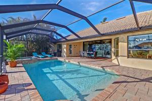 una piscina con patio e una casa di Villa Maya Serenity a Cape Coral