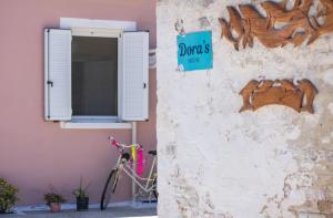 een fiets geparkeerd naast een muur met een raam bij Doras Beach Bungalow B in Plános