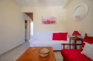 Doras Beach Bungalow B في بلانوس: غرفة معيشة مع سرير وسيارة حمراء على الحائط
