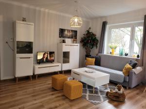 uma sala de estar com um sofá e uma televisão em FAMILY APARTMENT LINZ Wohnen mit Garten am Fusse des Pöstlingbergs TOP LAGE Villenviertel em Linz