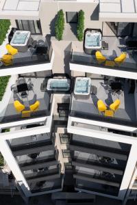 uma vista aérea de um edifício com cadeiras e mesas amarelas em LUX&EASY Athens Metro Suites em Atenas